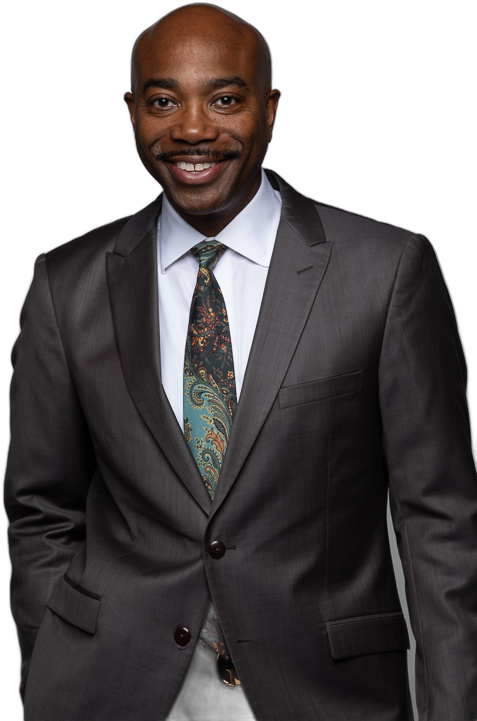 Dr. Bartholomew Orr smiling, wearing a charcoal suit and paisley tie