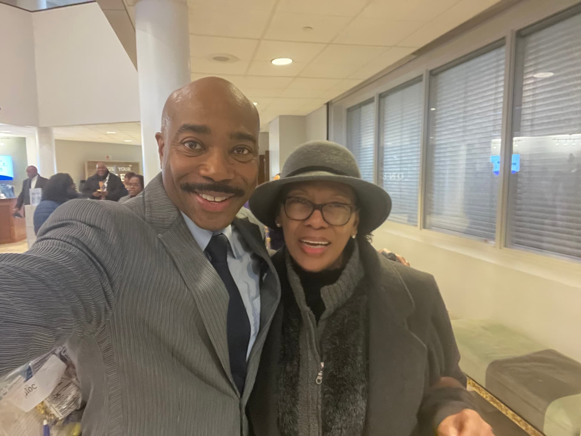 Dr. Orr taking a selfie with a church member in a gray hat in the church lobby