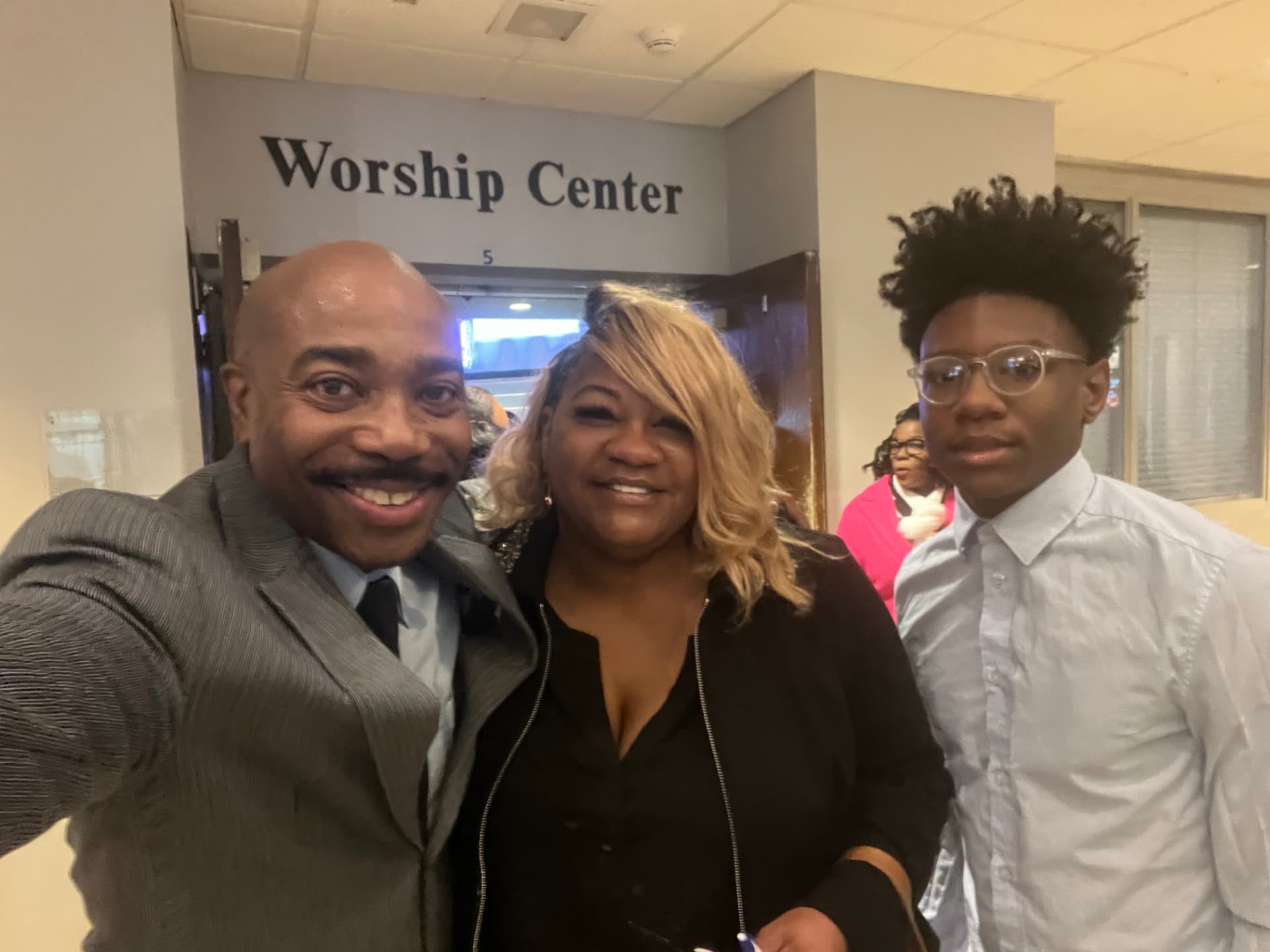 Dr. Orr taking a selfie with two church members in front of the Worship Center doors